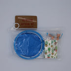 Survival kit with blue container, brown label, and patterned bag